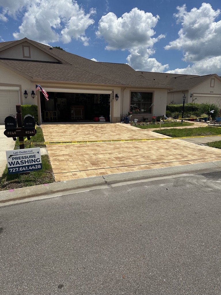 Clean, freshly sealed golden paver driveway in Palm Harbor after service