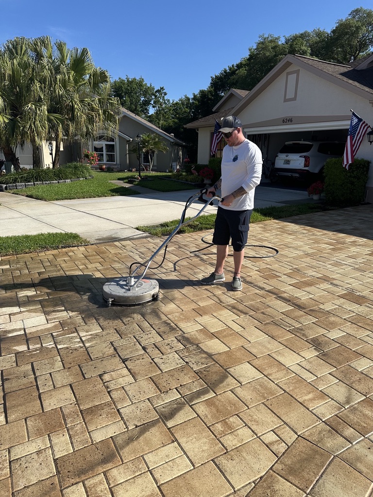 Lati-Dudes technician using a surface cleaner on a Palm Harbor paver driveway
