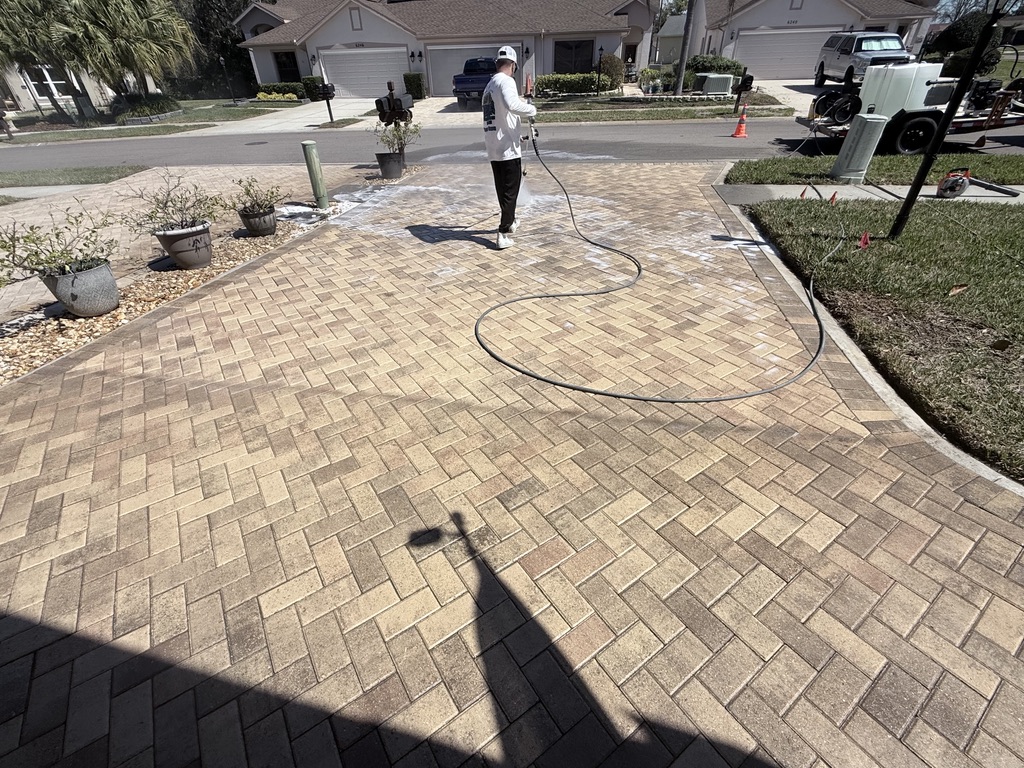 Lati-Dudes technician pressure washing a Palm Harbor paver driveway